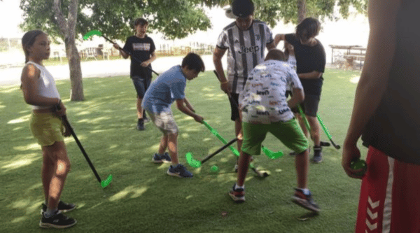Campamento urbano granja escuela en Alcalá de Henares juego hockey